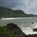 A local surfer rides a big wave on a rare day into Montezuma from the point.